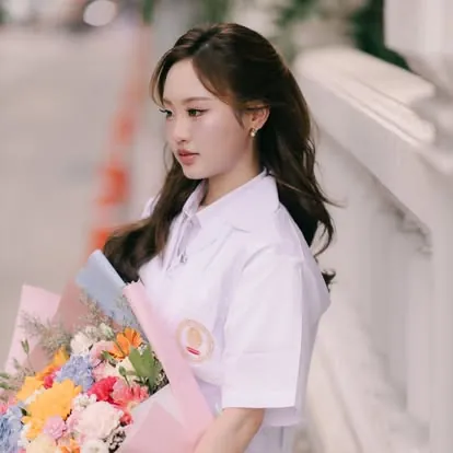 บัณฑิตถือช่อดอกไม้ริมระเบียงตึกเรียน