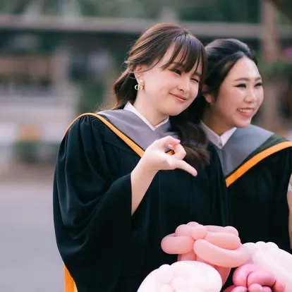 บัณฑิตชุดครุยกับเพื่อนในวันรับปริญญา